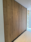 Hoge maatwerk kastenwand met natuurlijke houtstructuur