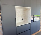 Luxe maatwerk keuken met goudkleurig kookeiland en donkere kastenwand