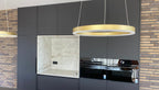 Luxe maatwerk keuken met goudkleurig kookeiland en donkere kastenwand