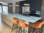 Luxe maatwerk keuken met goudkleurig kookeiland en donkere kastenwand