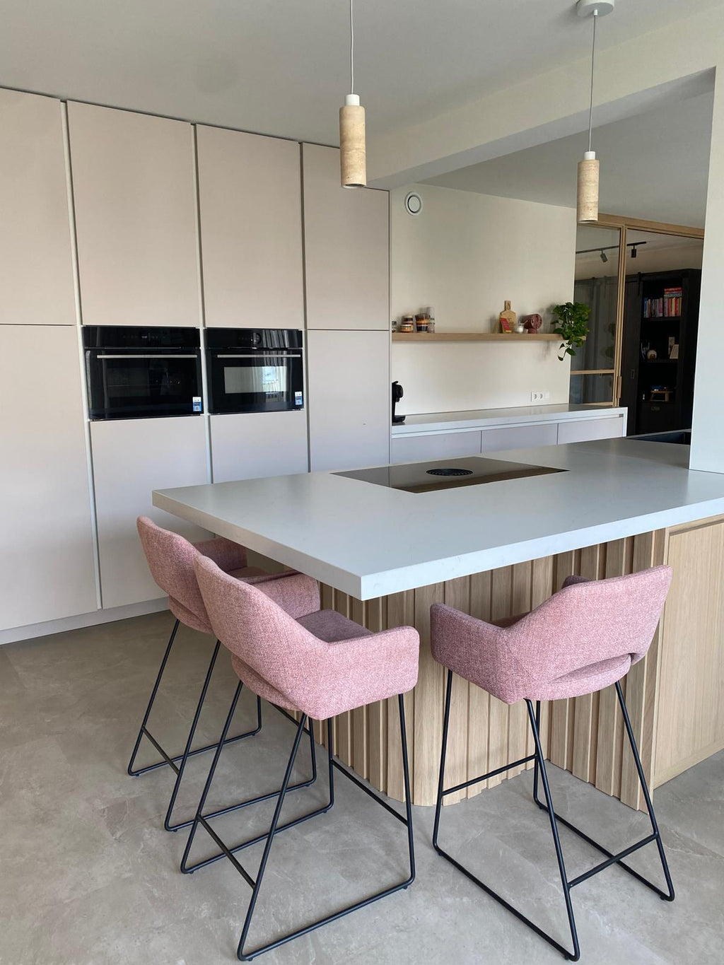 Lichte maatwerk leefkeuken met houten kookeiland en zitgedeelte