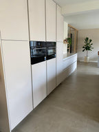 Lichte maatwerk leefkeuken met houten kookeiland en zitgedeelte
