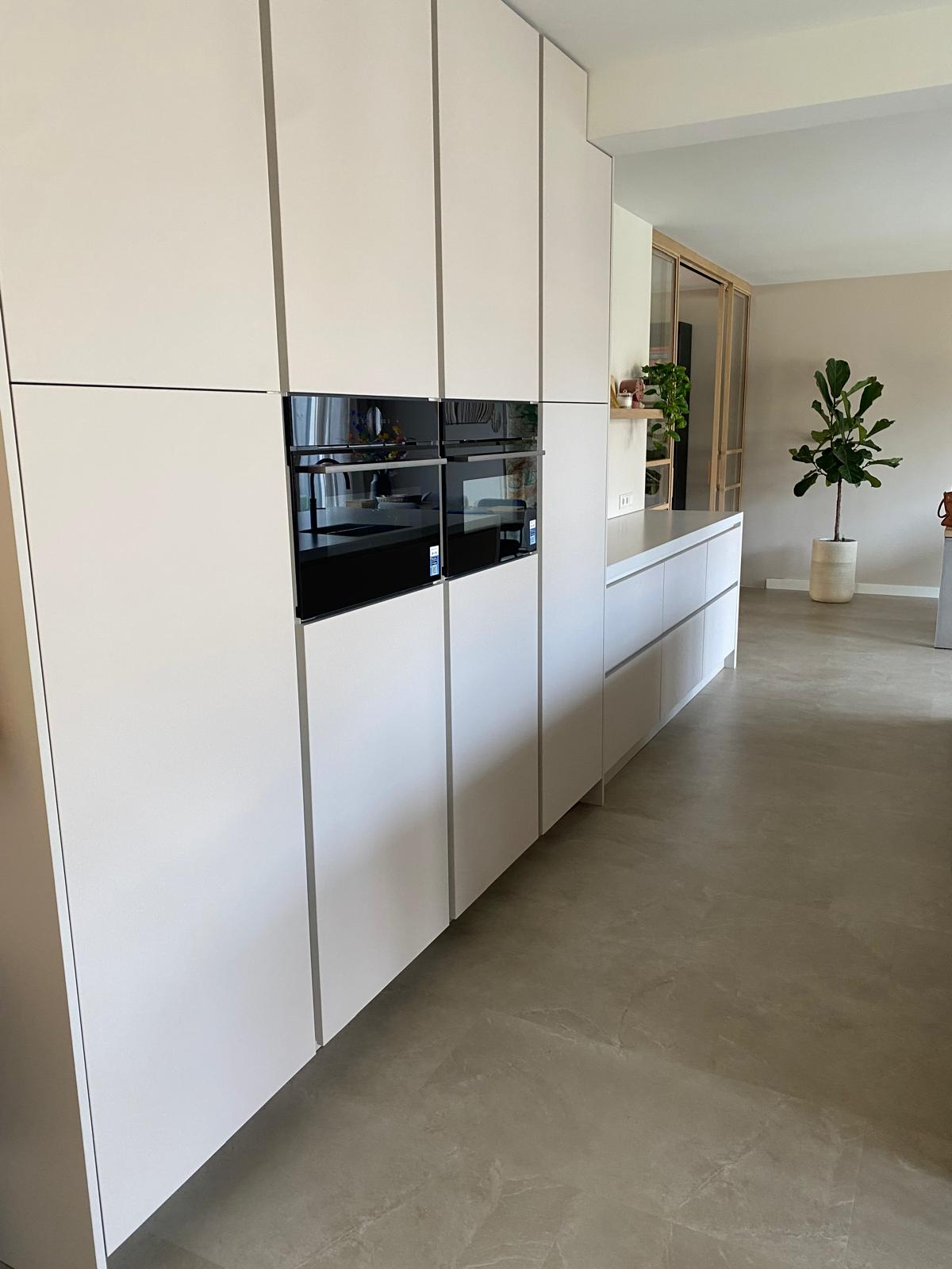 Lichte maatwerk leefkeuken met houten kookeiland en zitgedeelte