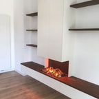 Maatwerk tv-wand met haard en donker houten wandplanken