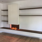 Maatwerk tv-wand met haard en donker houten wandplanken