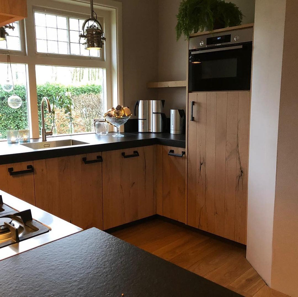 Landelijke maatwerk keuken met eiken fronten en zwart werkblad