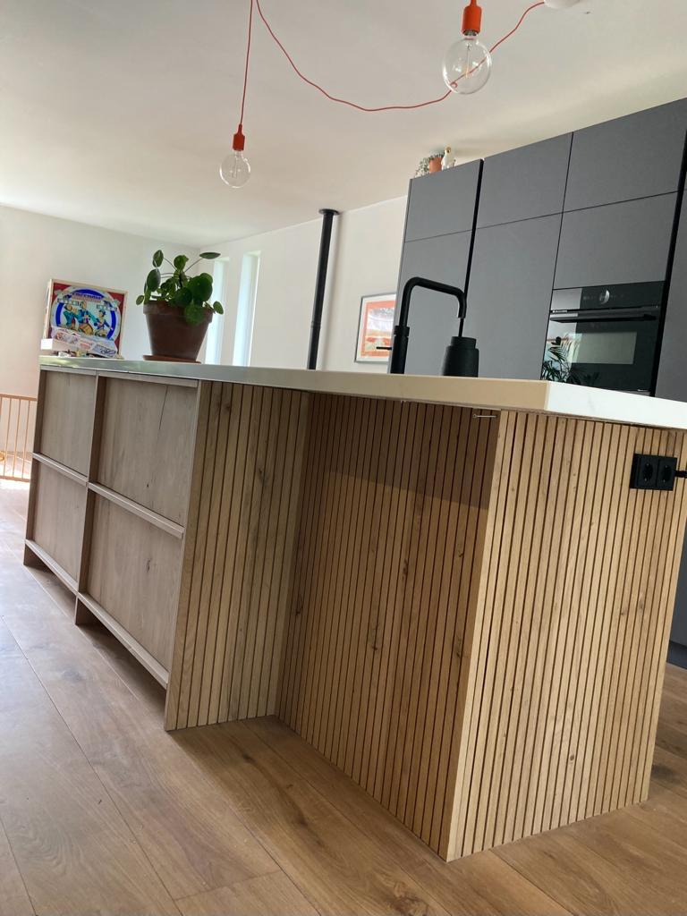 Maatwerk kookeiland met houten latten en een licht werkblad